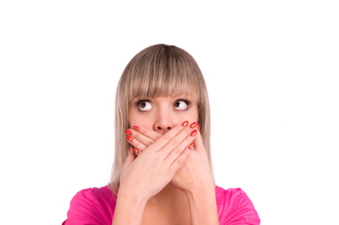 Quiet. Young woman with her finger on lips.